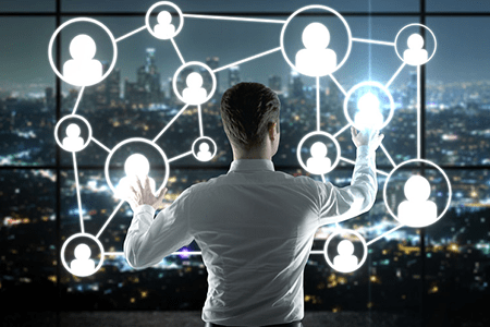 A person in a white shirt interacts with a digital network of connected profiles against a city skyline, symbolizing data networking and connectivity.