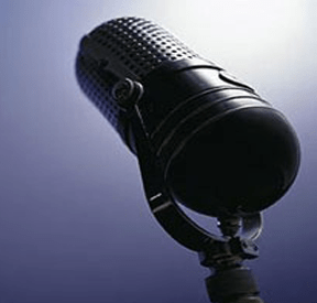 Vintage black microphone against a soft blue background, symbolizing audio production and vocal performance. Perfect for music or podcast topics.