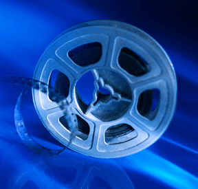 Silver film reel on a blue backdrop, symbolizing cinema and film production. Highlights the importance of visual storytelling in media.